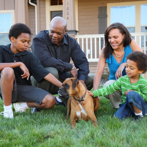 Family of four with dog outside home